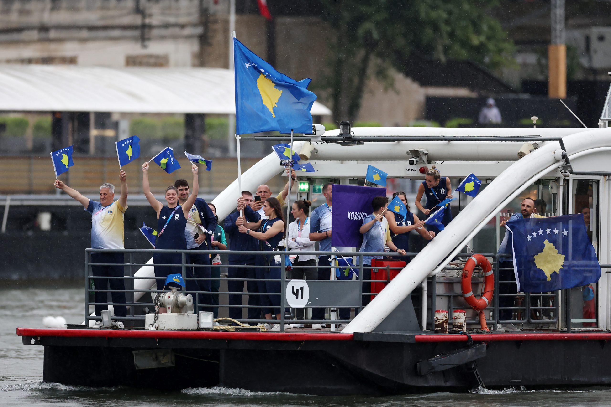 PARIS, FRANCE - JULY 26: Nora Gjakova and Akil Gjakova, Flagbearers of Team Kosovo, wave their flag on the team boat along the River Seine during the opening ceremony of the Olympic Games Paris 2024 on July 26, 2024 in Paris, France. (Photo by Maja Hitij/Getty Images)